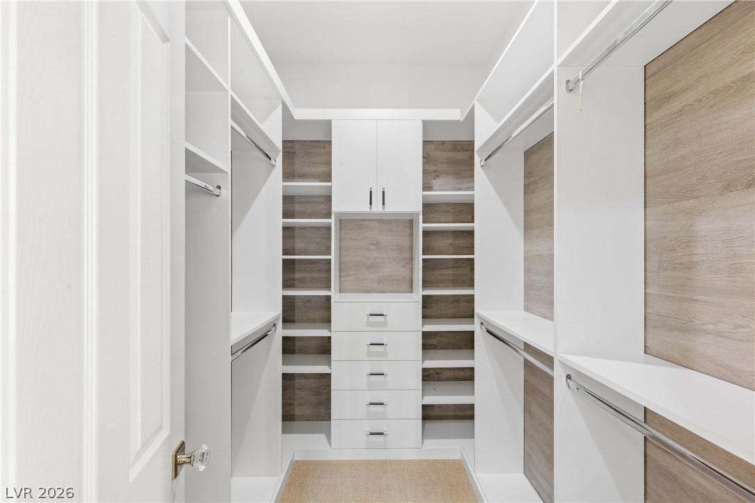 2575 Turtle Head Peak Drive, Las Vegas, NV 89135 Custom floor-to-ceiling shelving and warm wood backing maximize storage in this walk-in closet.