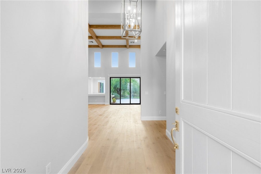 2575 Turtle Head Peak Drive, Las Vegas, NV 89135 An inviting entrance foyer reveals light hardwood floors and distant beamed ceilings.