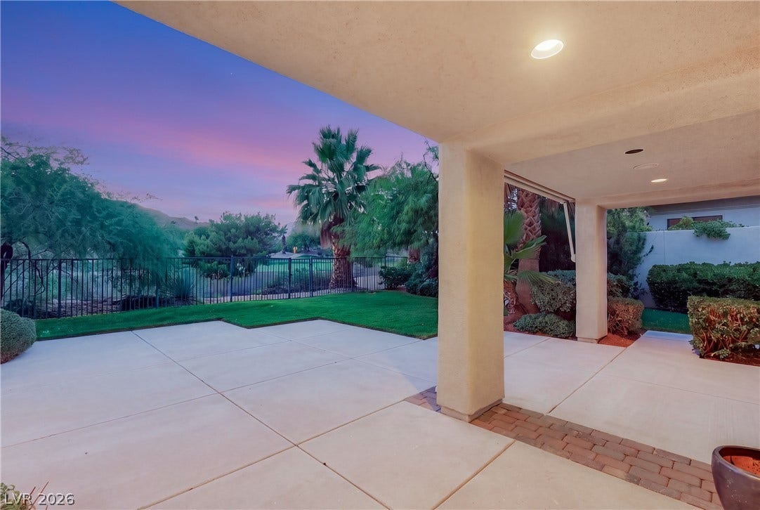 2575 Turtle Head Peak Drive, Las Vegas, NV 89135 A spacious covered patio overlooks a manicured lawn framed by classic wrought iron fencing.
