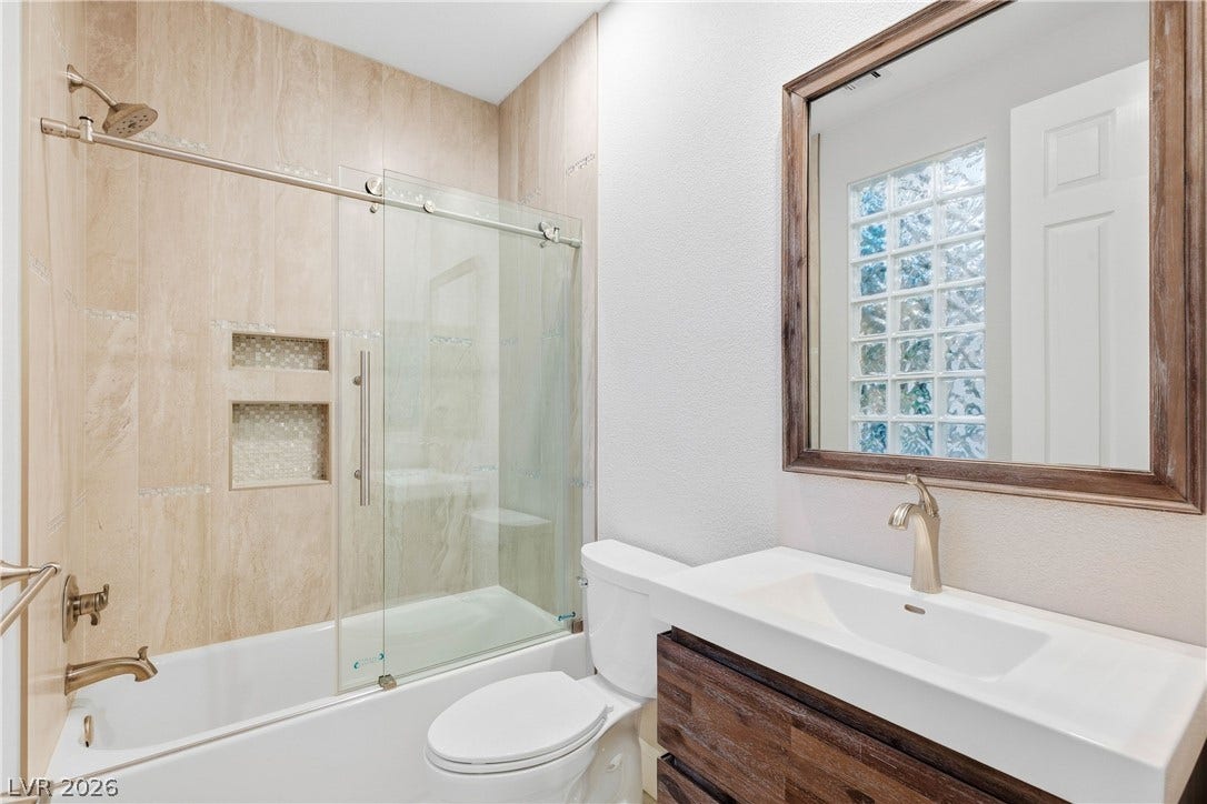 2575 Turtle Head Peak Drive, Las Vegas, NV 89135 A sleek modern vanity pairs beautifully with a glass-enclosed tub in this neutral bathroom.