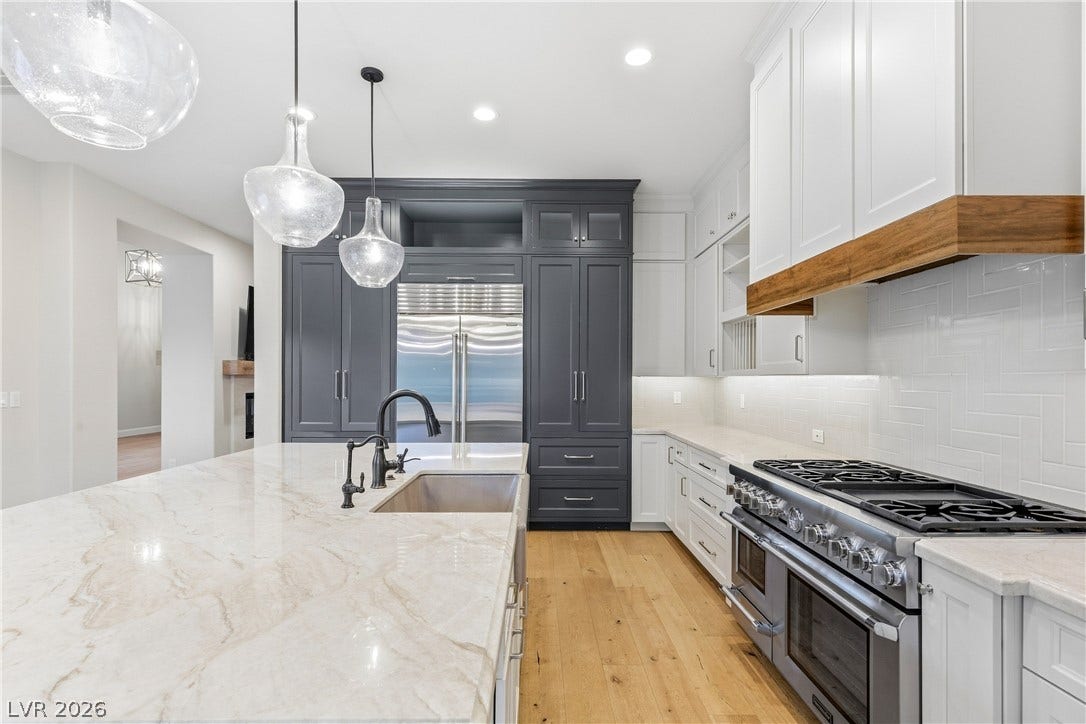 2575 Turtle Head Peak Drive, Las Vegas, NV 89135 Gleaming stone countertops and premium stainless appliances anchor this custom designed kitchen.