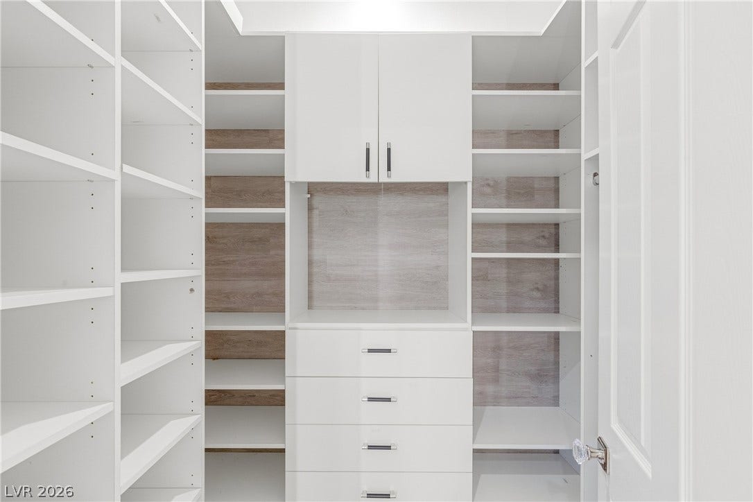 2575 Turtle Head Peak Drive, Las Vegas, NV 89135 Floor-to-ceiling custom shelving and integrated drawers maximize storage efficiency in this walk-in closet.