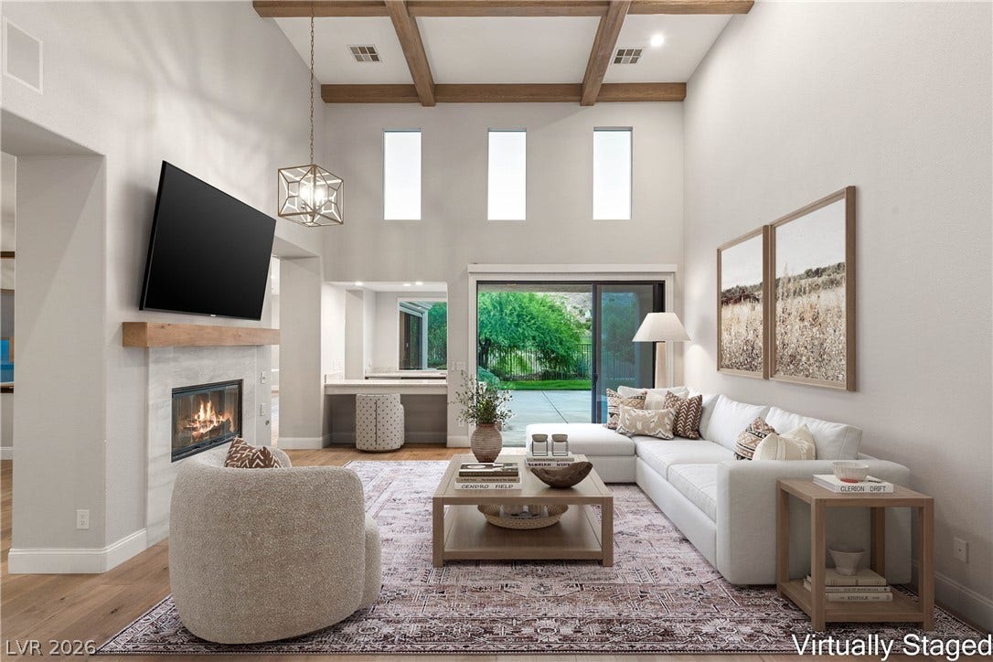 2575 Turtle Head Peak Drive, Las Vegas, NV 89135 Exposed ceiling beams and a stone fireplace anchor this soaring, light-filled gathering space.