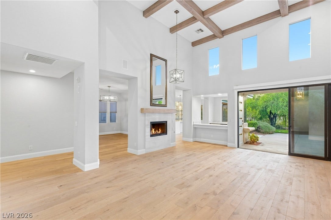 2575 Turtle Head Peak Drive, Las Vegas, NV 89135 Exposed wood beams and a modern fireplace anchor this light-filled, open-concept living space.