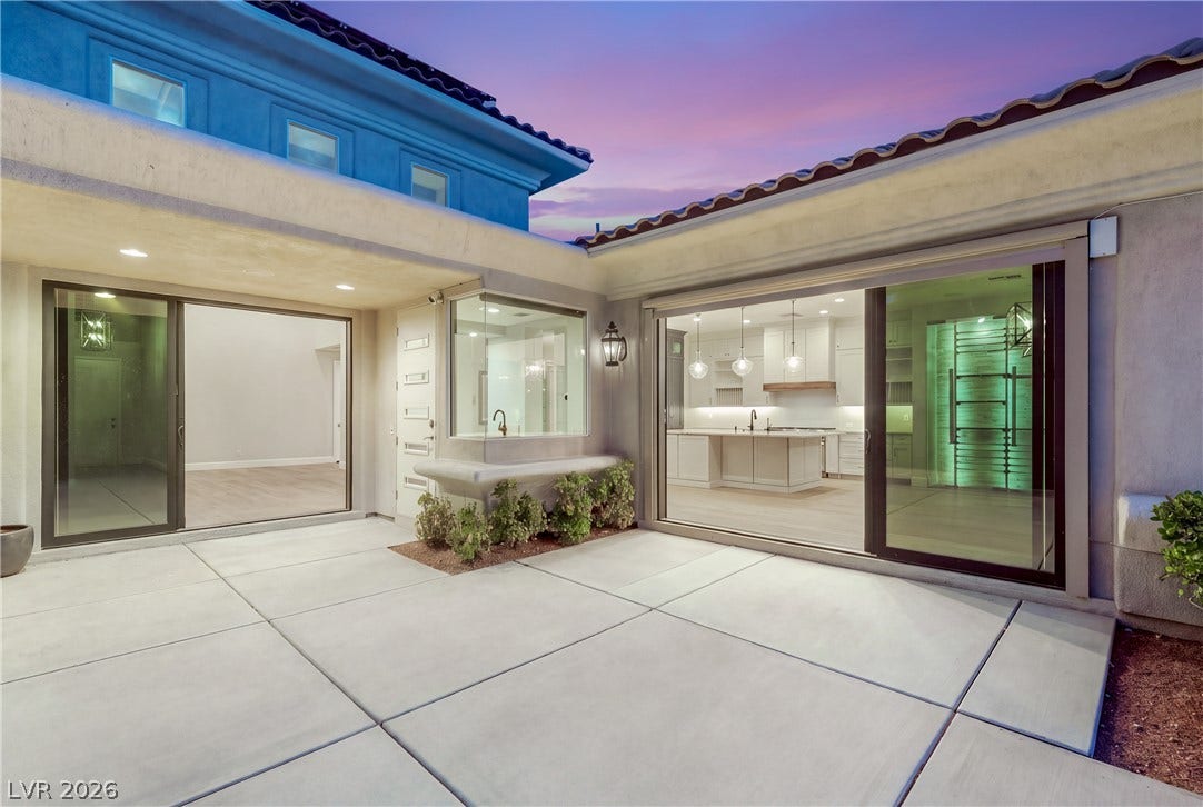 2575 Turtle Head Peak Drive, Las Vegas, NV 89135 Sliding glass doors connect the concrete courtyard seamlessly to the modern open-concept interior.