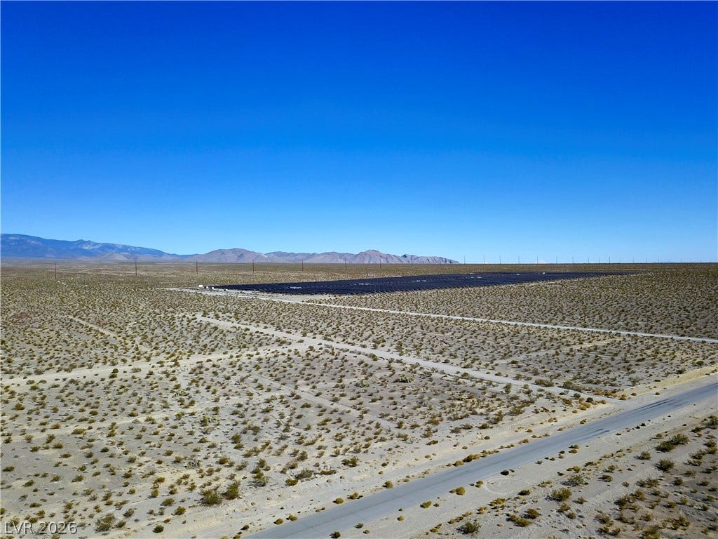 2180 E Simkins Road, Pahrump, NV 89060 Panoramic mountain views highlight this expansive desert acreage under clear blue skies.