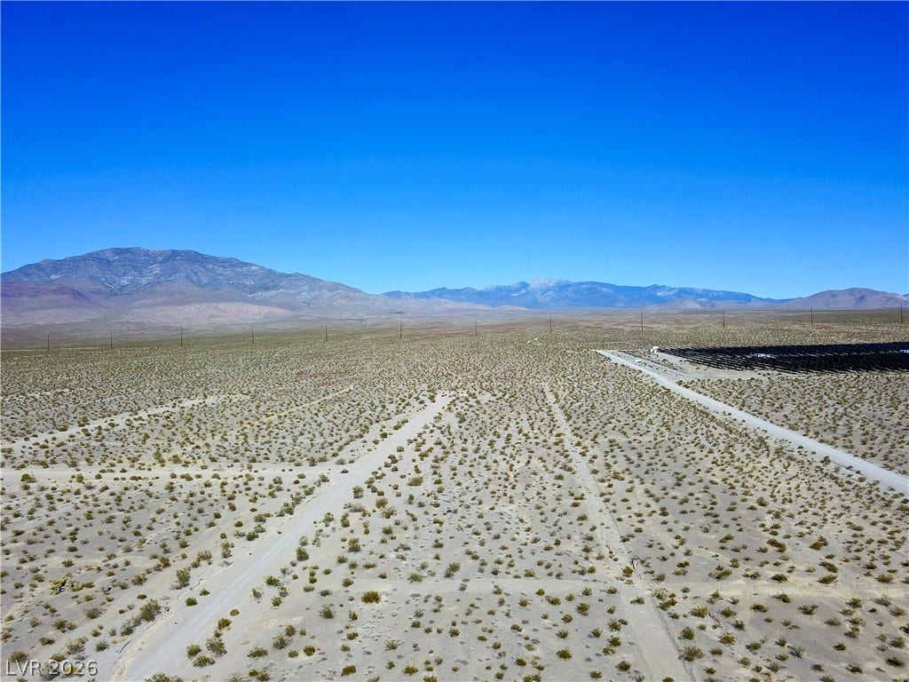2180 E Simkins Road, Pahrump, NV 89060 Vast desert acreage offers expansive views of surrounding mountain ranges under clear blue skies.