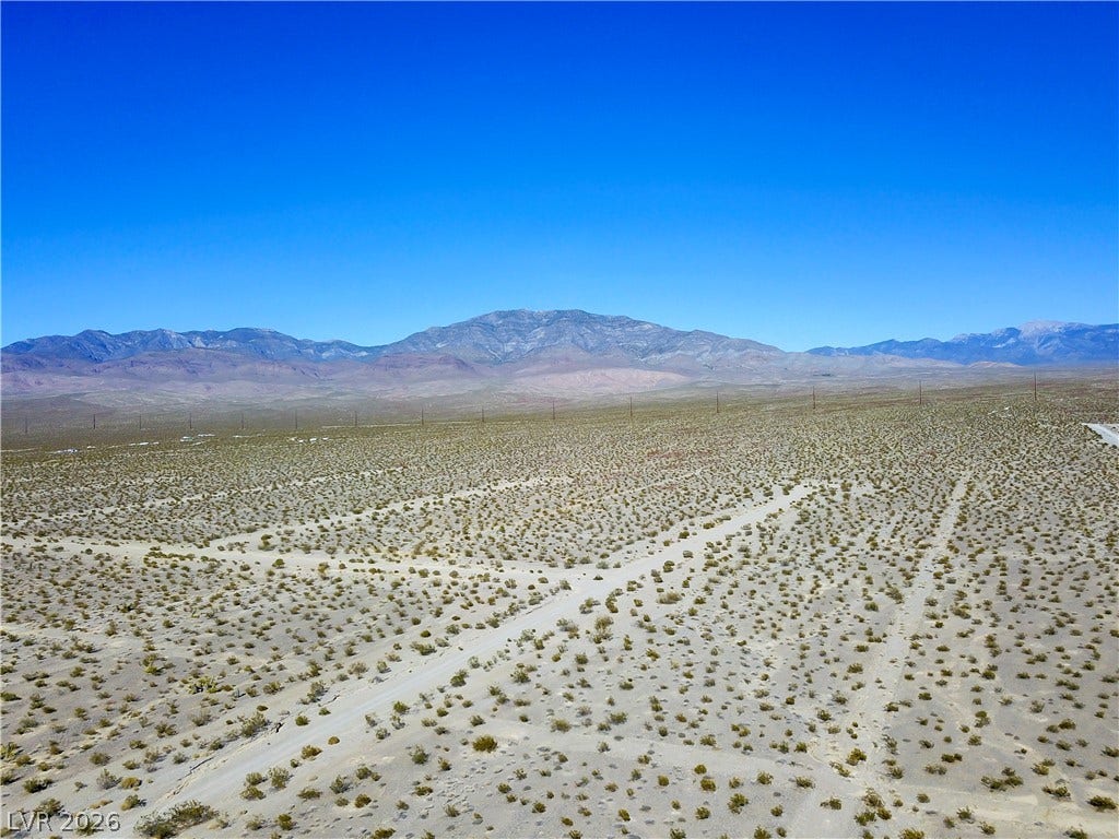 2180 E Simkins Road, Pahrump, NV 89060 Vast desert landscape captures sweeping mountain views under a clear blue sky.