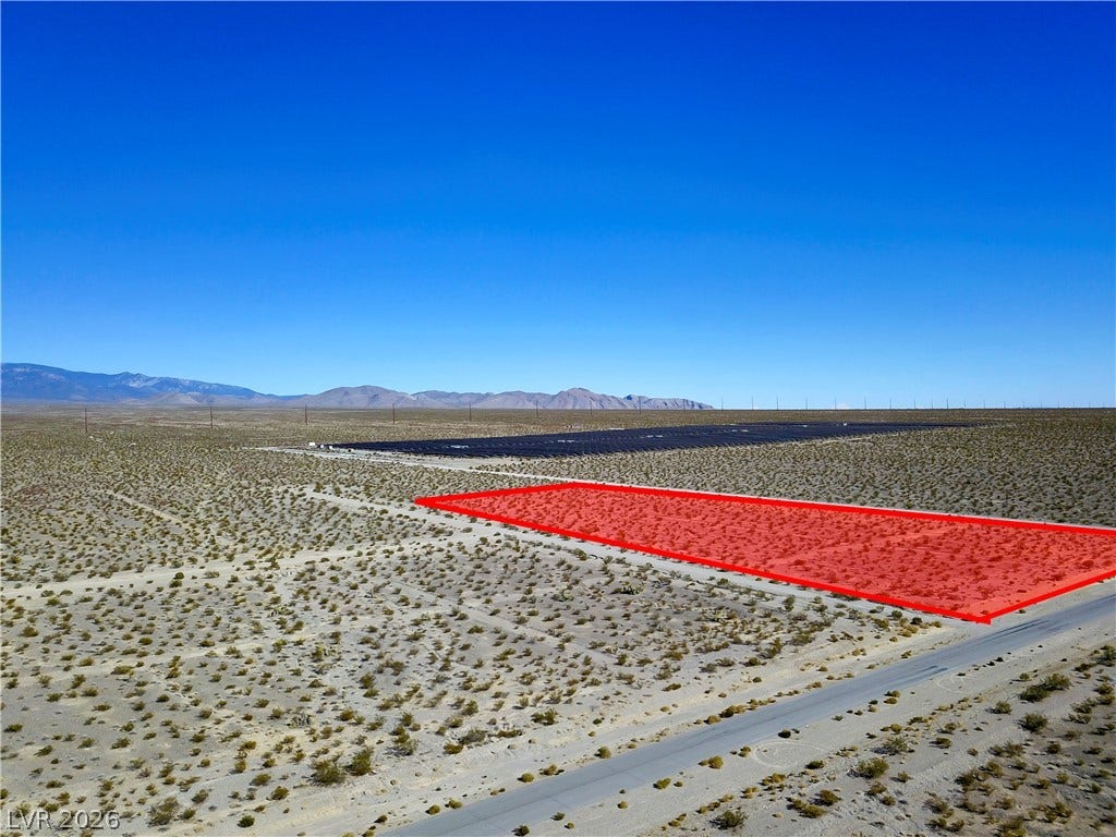 2180 E Simkins Road, Pahrump, NV 89060 An expansive desert parcel offers paved road access under clear blue skies.