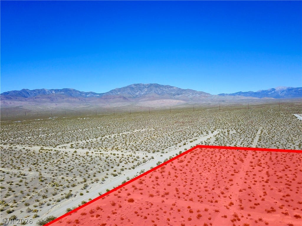 2180 E Simkins Road, Pahrump, NV 89060 Dramatic mountain vistas frame this vast desert lot under wide open blue skies.