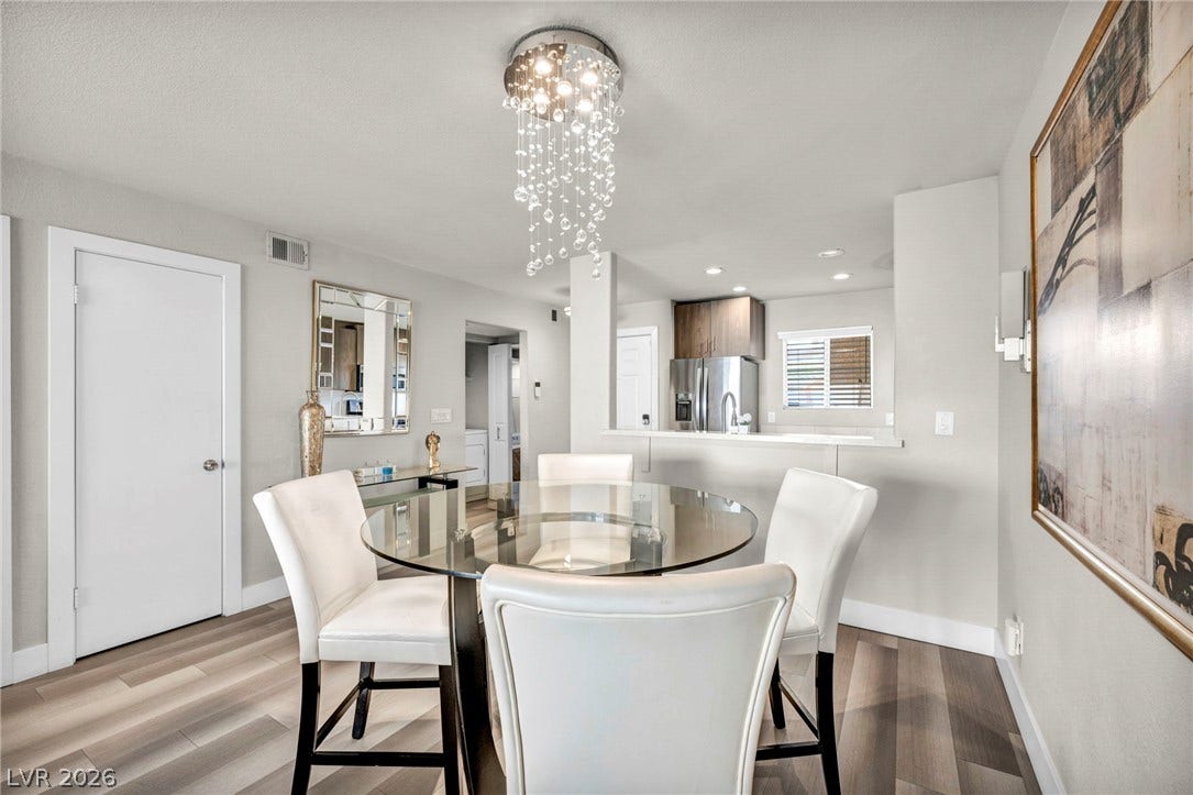 An elegant modern dining space connects seamlessly with the adjacent kitchen.