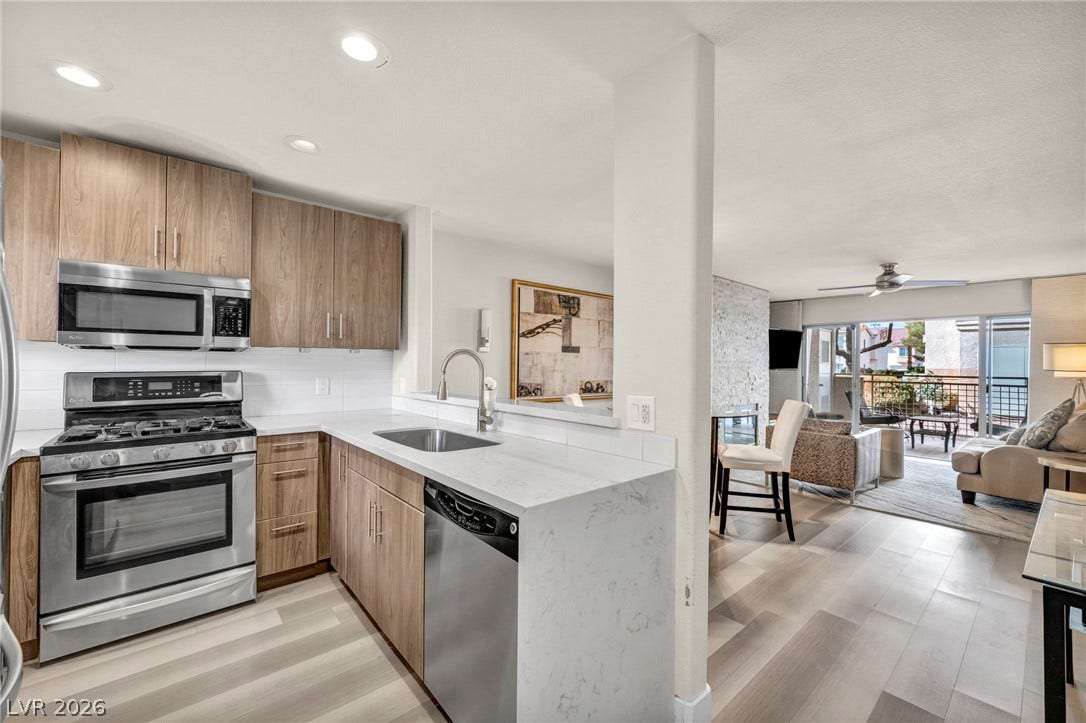 Modern cabinetry and stone countertops anchor this open kitchen flowing into the great room.