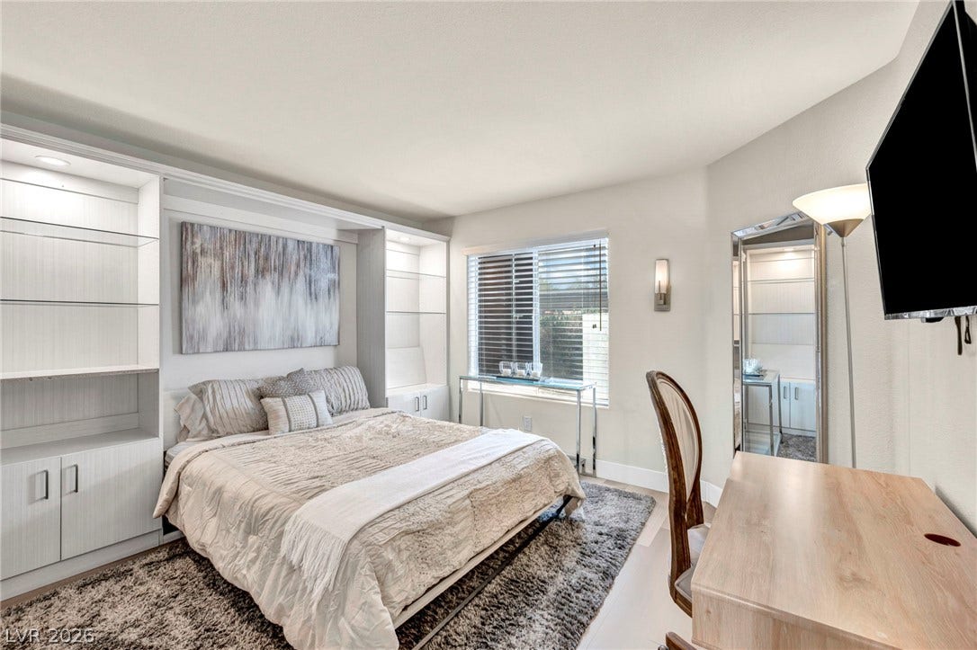 Custom built-in shelving surrounds the bed in this versatile guest bedroom, ideal for a guest bedroom or home office.
