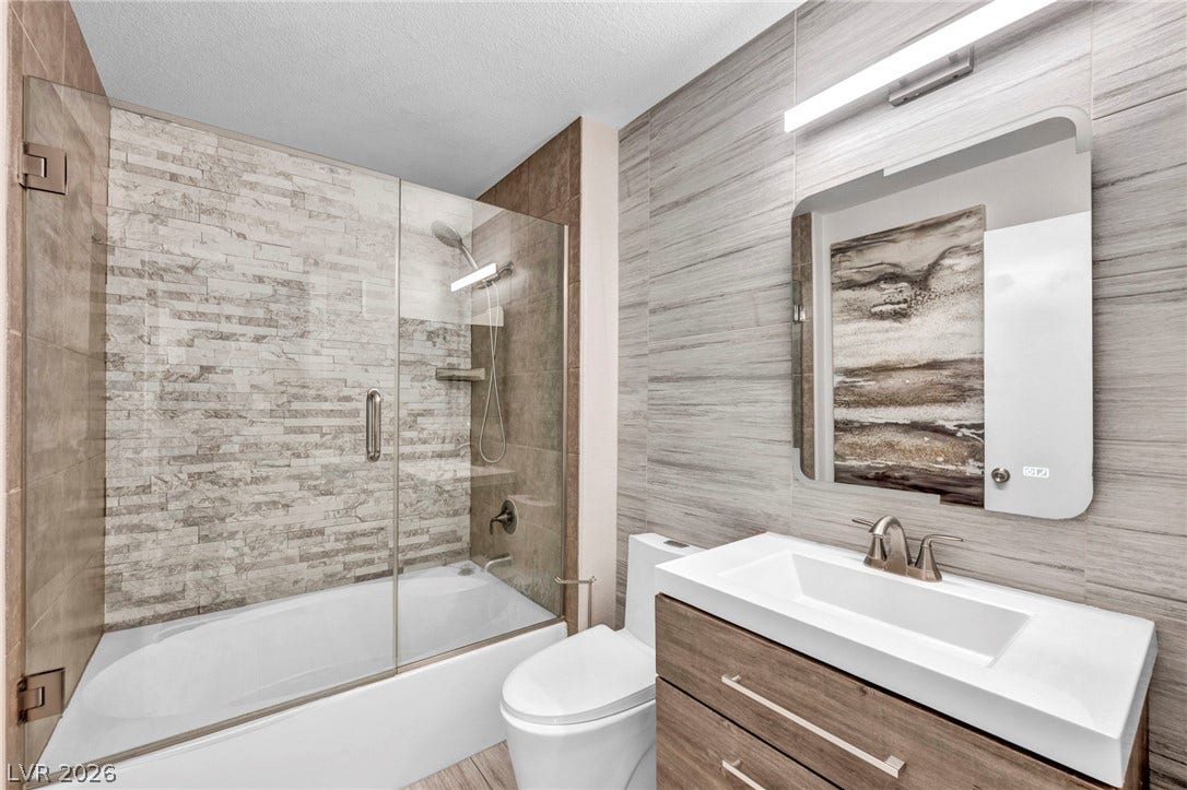 Textured tile walls and a modern vanity define this contemporary bathroom space.