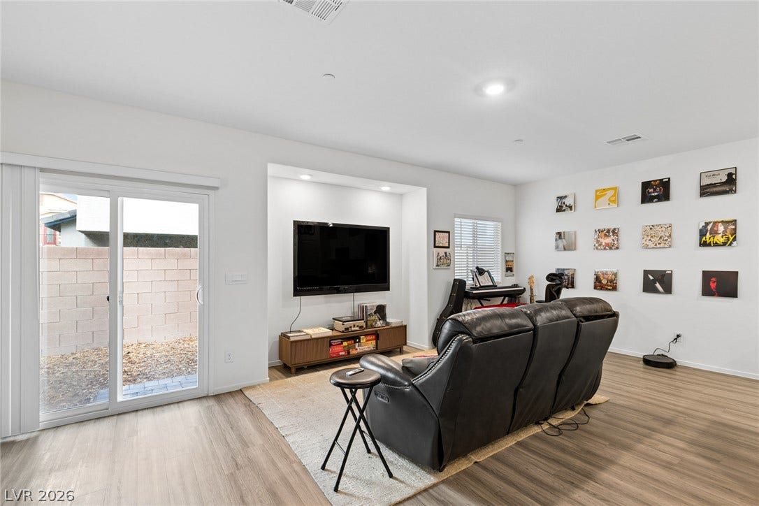 7910 Aurora Sky Street, North Las Vegas, NV 89084 Sliding glass doors open directly to the yard from this modern living space.