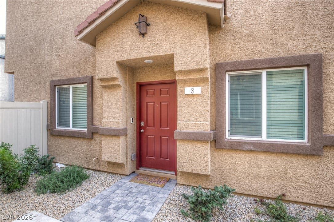 7910 Aurora Sky Street, North Las Vegas, NV 89084 A welcoming stone-paved pathway leads directly to the covered front entrance of this stucco home.
