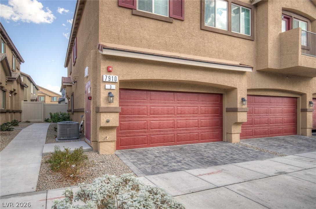 7910 Aurora Sky Street, North Las Vegas, NV 89084 Warm stucco exterior walls harmonize beautifully with a paved driveway and classic garage doors.