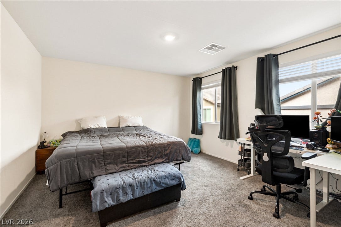 7910 Aurora Sky Street, North Las Vegas, NV 89084 A spacious secondary bedroom features soft plush carpeting and dual windows overlooking the neighborhood.