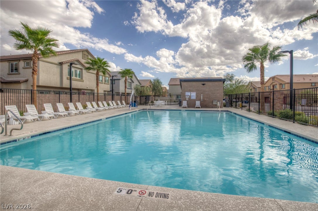 7910 Aurora Sky Street, North Las Vegas, NV 89084 An inviting community swimming pool is surrounded by palm trees and gated security fencing.
