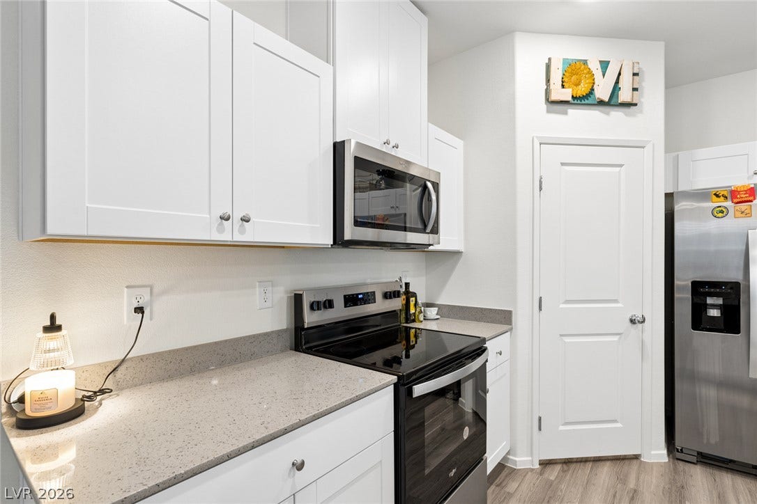 7910 Aurora Sky Street, North Las Vegas, NV 89084 Crisp white cabinetry pairs with durable stone countertops and stainless steel appliances in this kitchen.