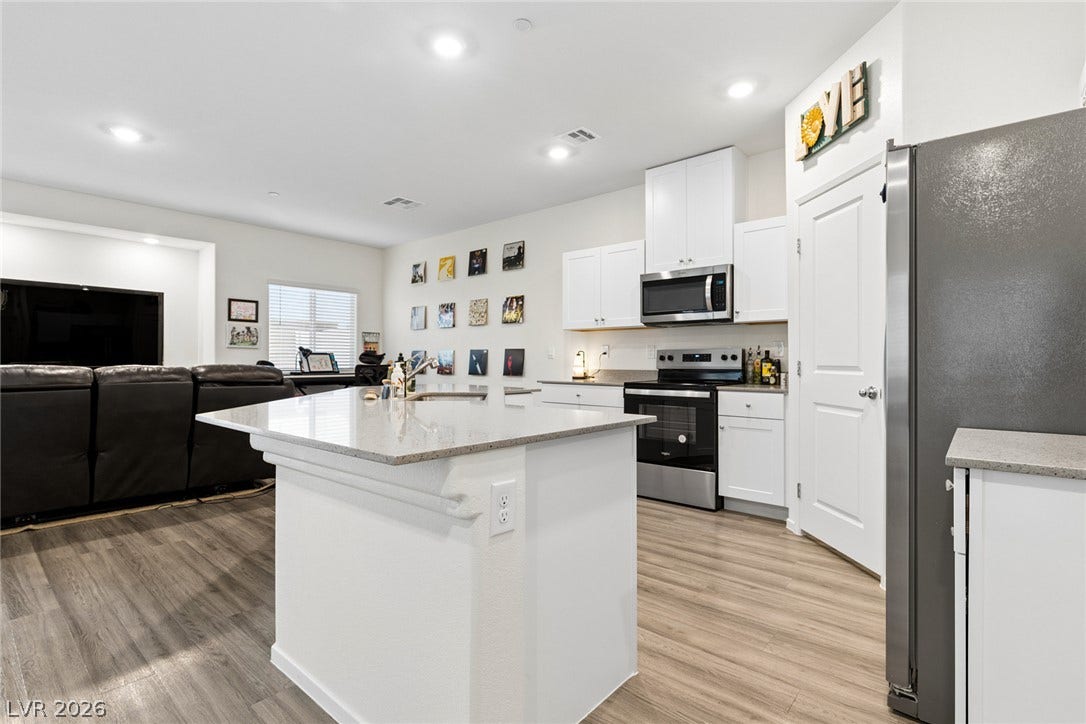 7910 Aurora Sky Street, North Las Vegas, NV 89084 Gleaming stone counters and custom cabinetry anchor a modern, airy kitchen layout.