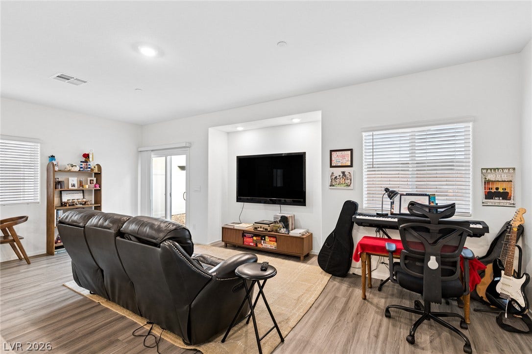 7910 Aurora Sky Street, North Las Vegas, NV 89084 Gleaming wood-look floors anchor a versatile living space equipped with recessed lighting.