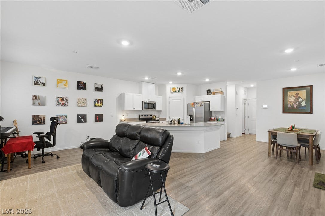 7910 Aurora Sky Street, North Las Vegas, NV 89084 Smooth wood-look flooring and recessed lighting span this versatile, open-concept living space.