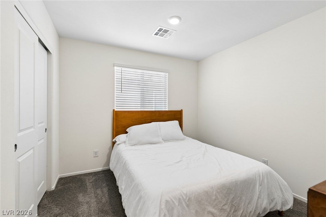 7910 Aurora Sky Street, North Las Vegas, NV 89084 Plush wall-to-wall carpeting and tall sliding closet doors define this cozy bedroom.