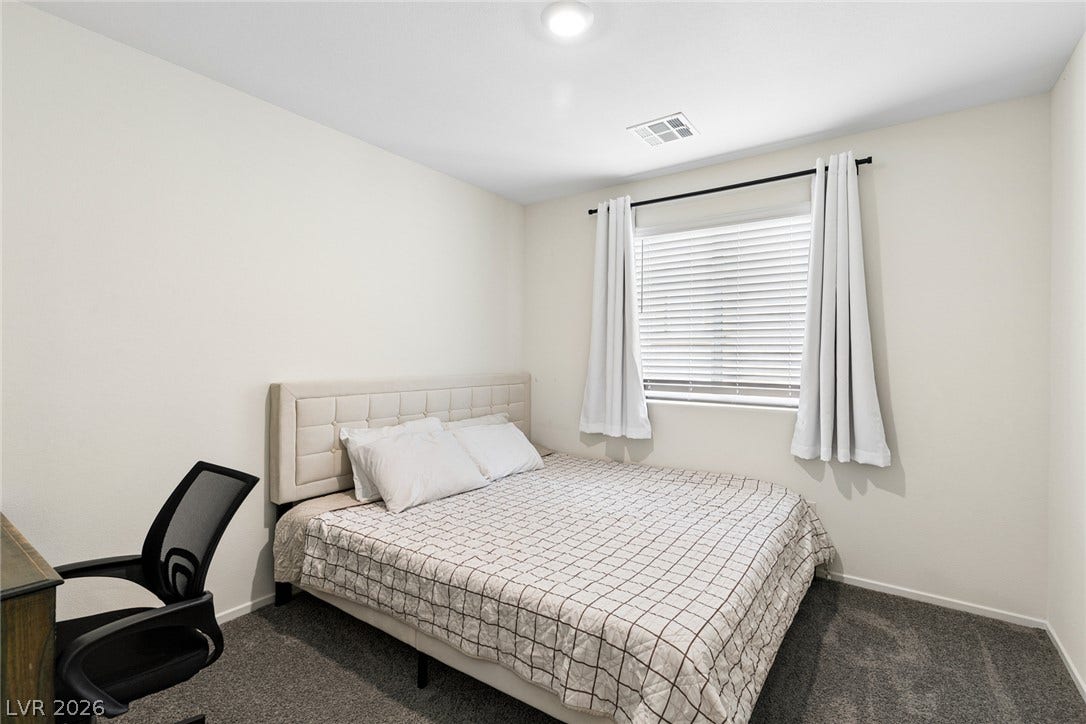 7910 Aurora Sky Street, North Las Vegas, NV 89084 Plush carpeting and a bright window create a comfortable, inviting atmosphere.