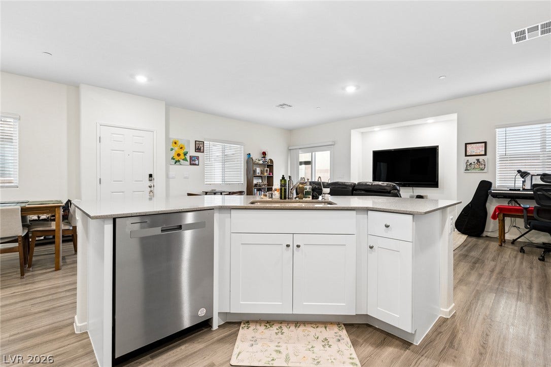 7910 Aurora Sky Street, North Las Vegas, NV 89084 An open floorplan seamlessly connects the stone-countertop kitchen island with adjacent living spaces.