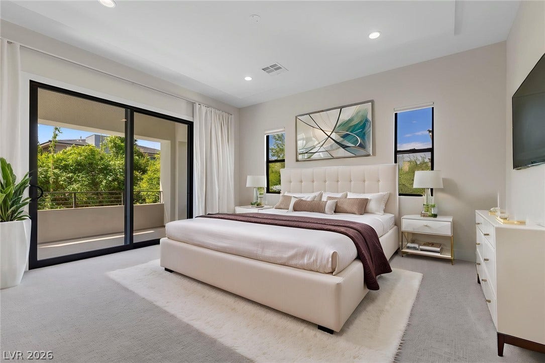 11453 Rhodolite Court, Las Vegas, NV 89135 Glass sliding doors open to a private balcony from this modern bedroom.