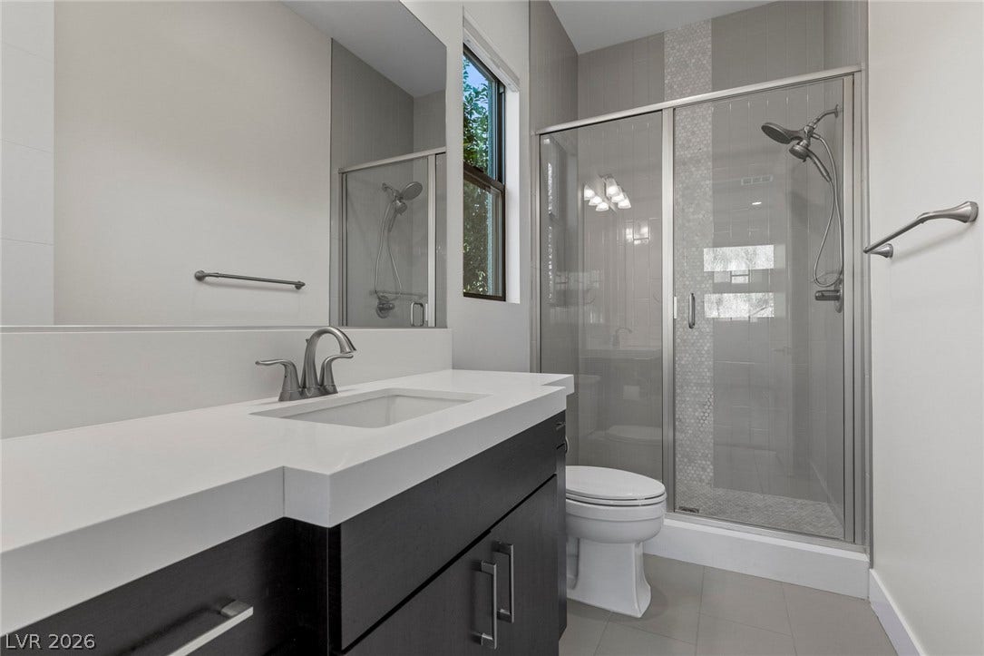 11453 Rhodolite Court, Las Vegas, NV 89135 Modern finishes define this bathroom featuring a glass-enclosed shower and sleek vanity.