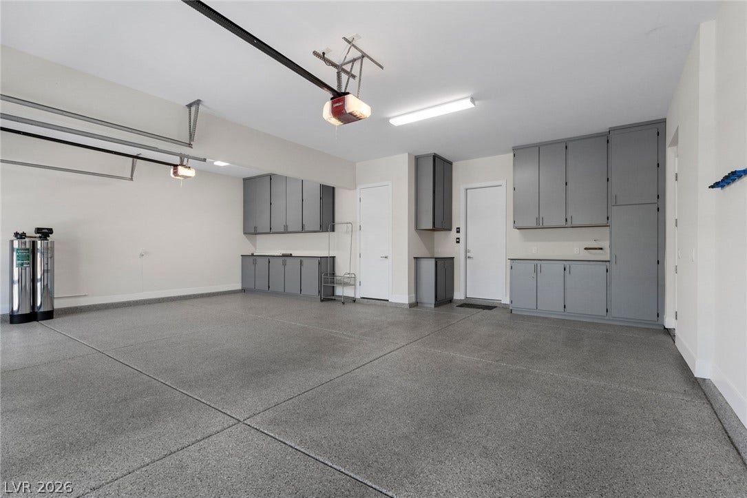 11453 Rhodolite Court, Las Vegas, NV 89135 Ample built-in cabinetry and finished floors elevate this functional garage space.