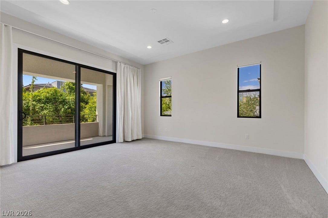 11453 Rhodolite Court, Las Vegas, NV 89135 Sliding glass doors open directly to a private balcony from this spacious bedroom.