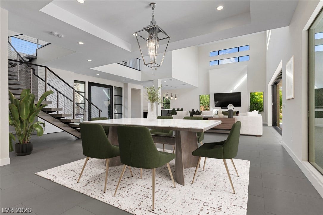 11453 Rhodolite Court, Las Vegas, NV 89135 Clean lines and soaring ceilings define this modern dining space featuring a dramatic open staircase.
