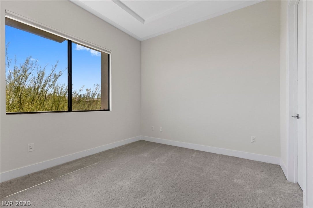 11453 Rhodolite Court, Las Vegas, NV 89135 Plush carpeting and a recessed tray ceiling define this light-filled room with desert views.