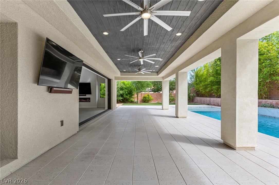 11453 Rhodolite Court, Las Vegas, NV 89135 A spacious covered patio sits alongside a sparkling pool, ideal for outdoor entertainment.