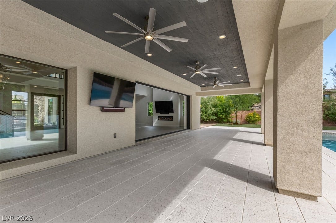 11453 Rhodolite Court, Las Vegas, NV 89135 An expansive covered patio features sleek tile flooring under a dark wood ceiling.