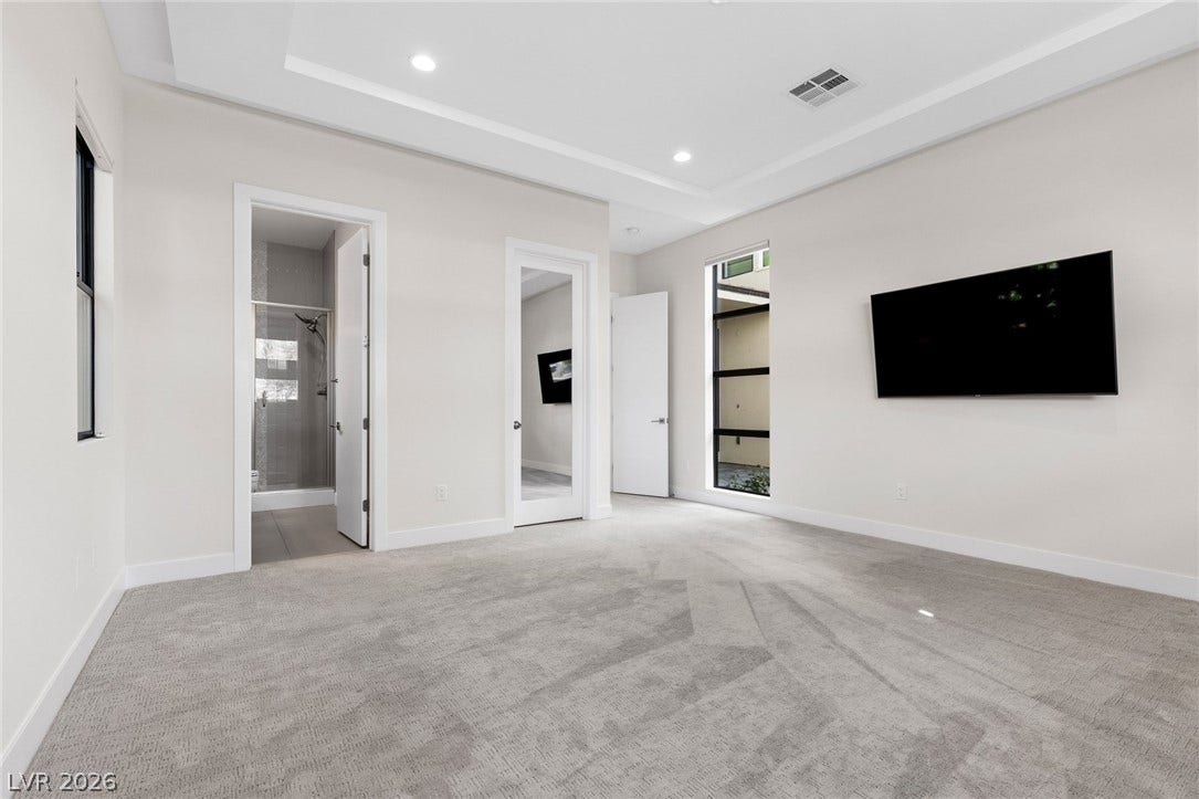 11453 Rhodolite Court, Las Vegas, NV 89135 Recessed lighting and tray ceilings elevate this carpeted bedroom suite.