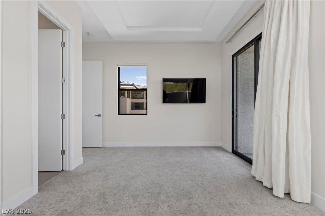 11453 Rhodolite Court, Las Vegas, NV 89135 Plush carpeting and a recessed tray ceiling define this modern, light-filled bedroom layout.