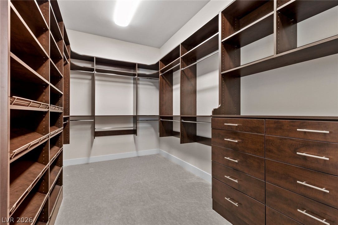 11453 Rhodolite Court, Las Vegas, NV 89135 Rich dark wood built-ins offer extensive organization space inside this carpeted closet.