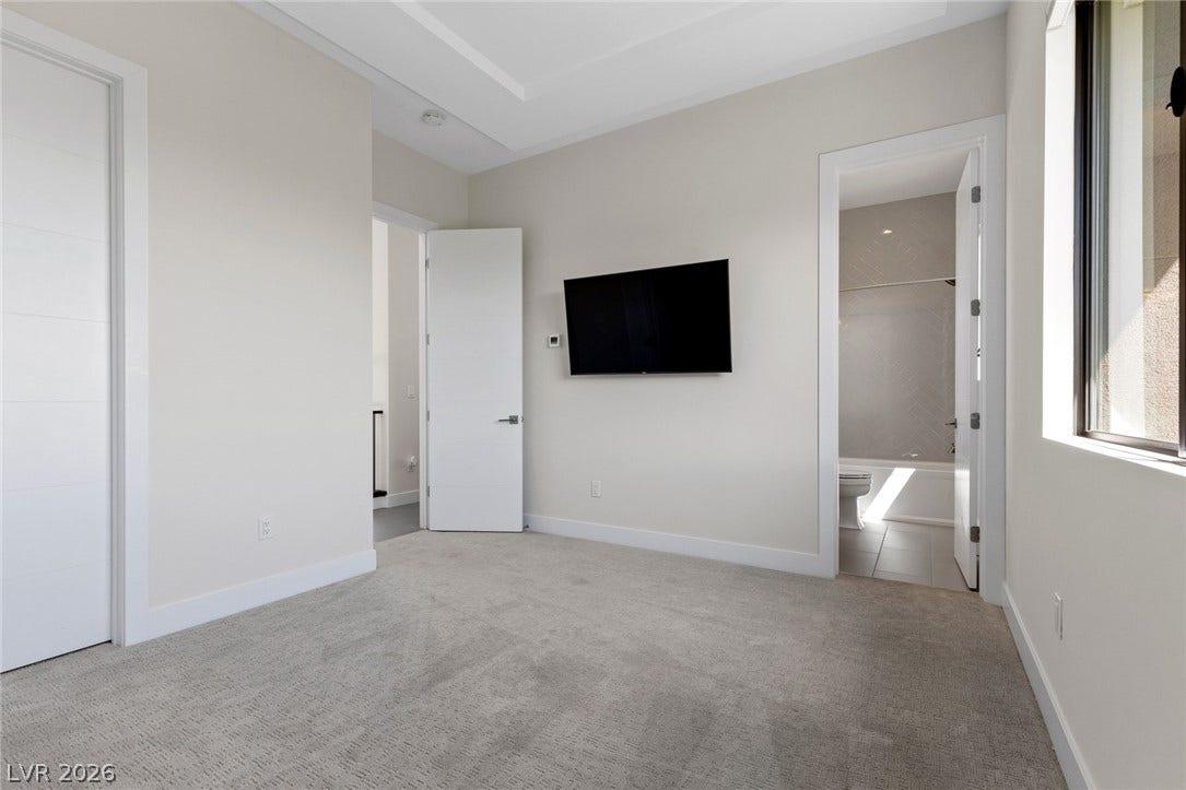11453 Rhodolite Court, Las Vegas, NV 89135 Recessed ceiling details and plush carpet define this peaceful bedroom with an attached bath.