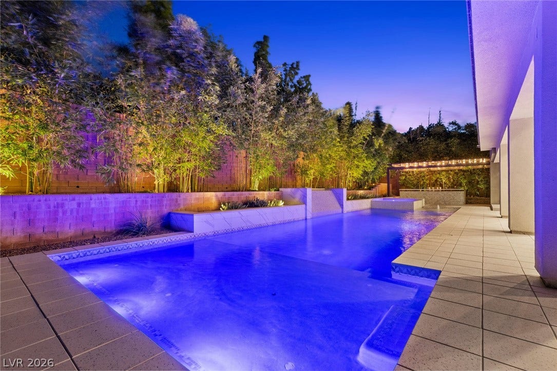 11453 Rhodolite Court, Las Vegas, NV 89135 A sparkling swimming pool flanked by a tiled terrace and lush bamboo privacy hedges.