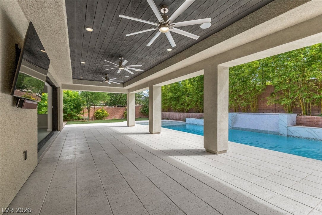 11453 Rhodolite Court, Las Vegas, NV 89135 An expansive covered patio features a wood-paneled ceiling alongside a pristine swimming pool.