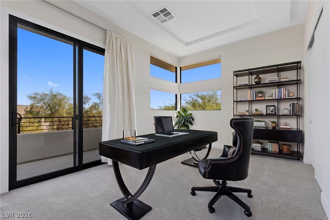 11453 Rhodolite Court, Las Vegas, NV 89135 Sliding glass doors open to a private balcony in this modern home office.