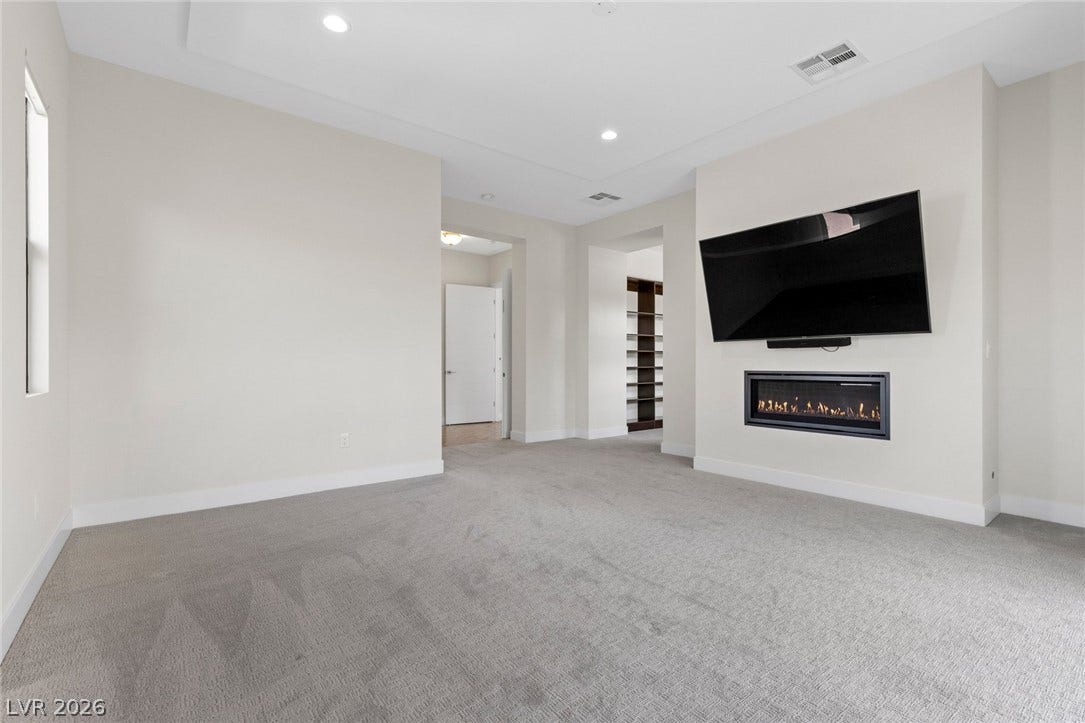 11453 Rhodolite Court, Las Vegas, NV 89135 Plush carpeting and a sleek fireplace define this comfortable living space.