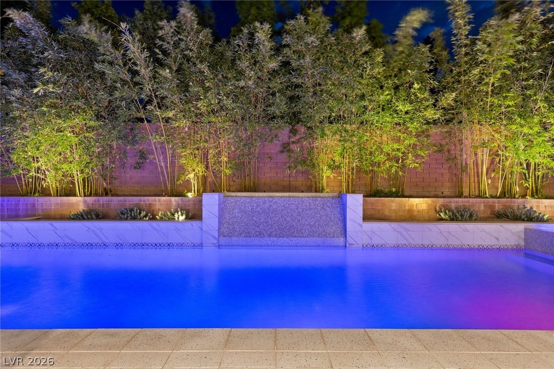 11453 Rhodolite Court, Las Vegas, NV 89135 Lush bamboo plantings and a stone waterfall feature border this private backyard swimming pool.