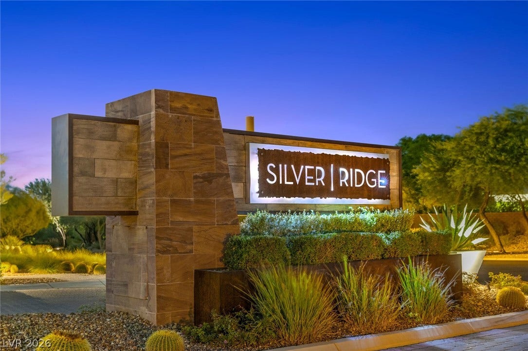 11453 Rhodolite Court, Las Vegas, NV 89135 A prominent stone monument sign marks the entrance to the desert community at twilight.