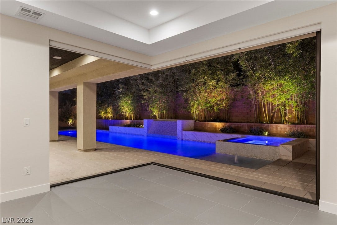 11453 Rhodolite Court, Las Vegas, NV 89135 Massive pocketing glass doors frame seamless transitions to a pool area.