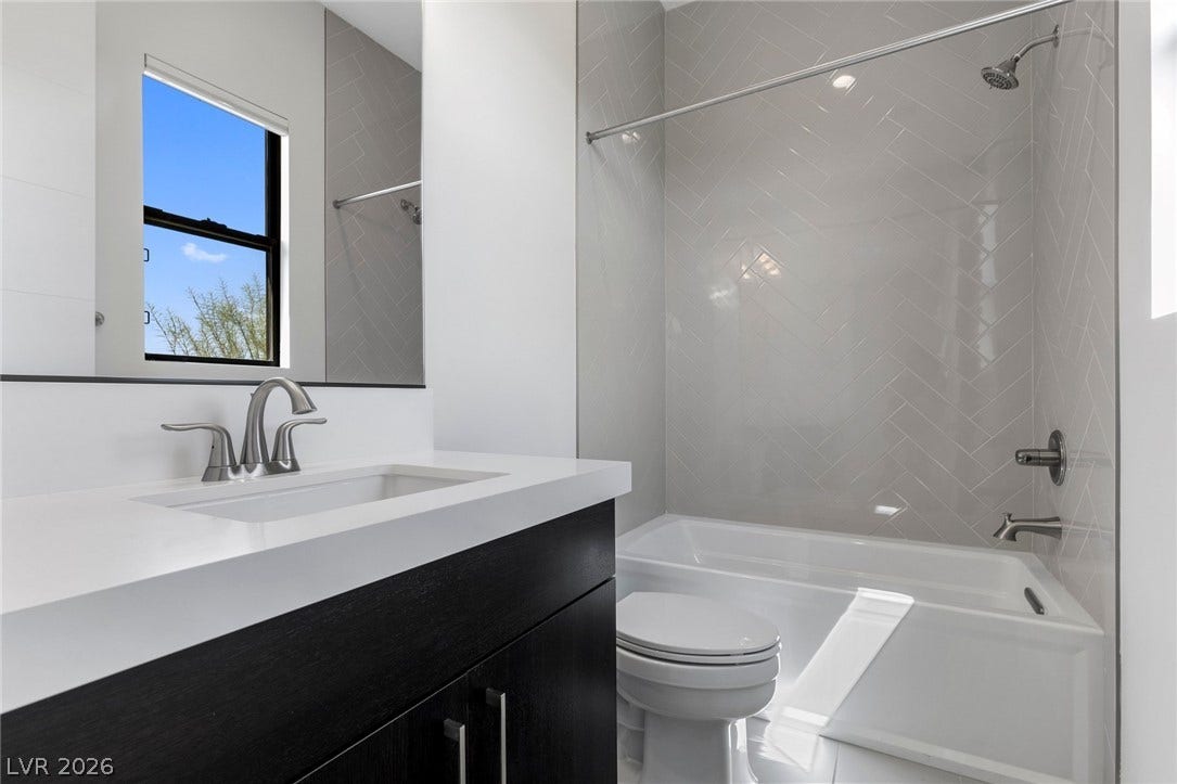 11453 Rhodolite Court, Las Vegas, NV 89135 A modern bathroom highlights a dark vanity paired with a tiled tub surround.